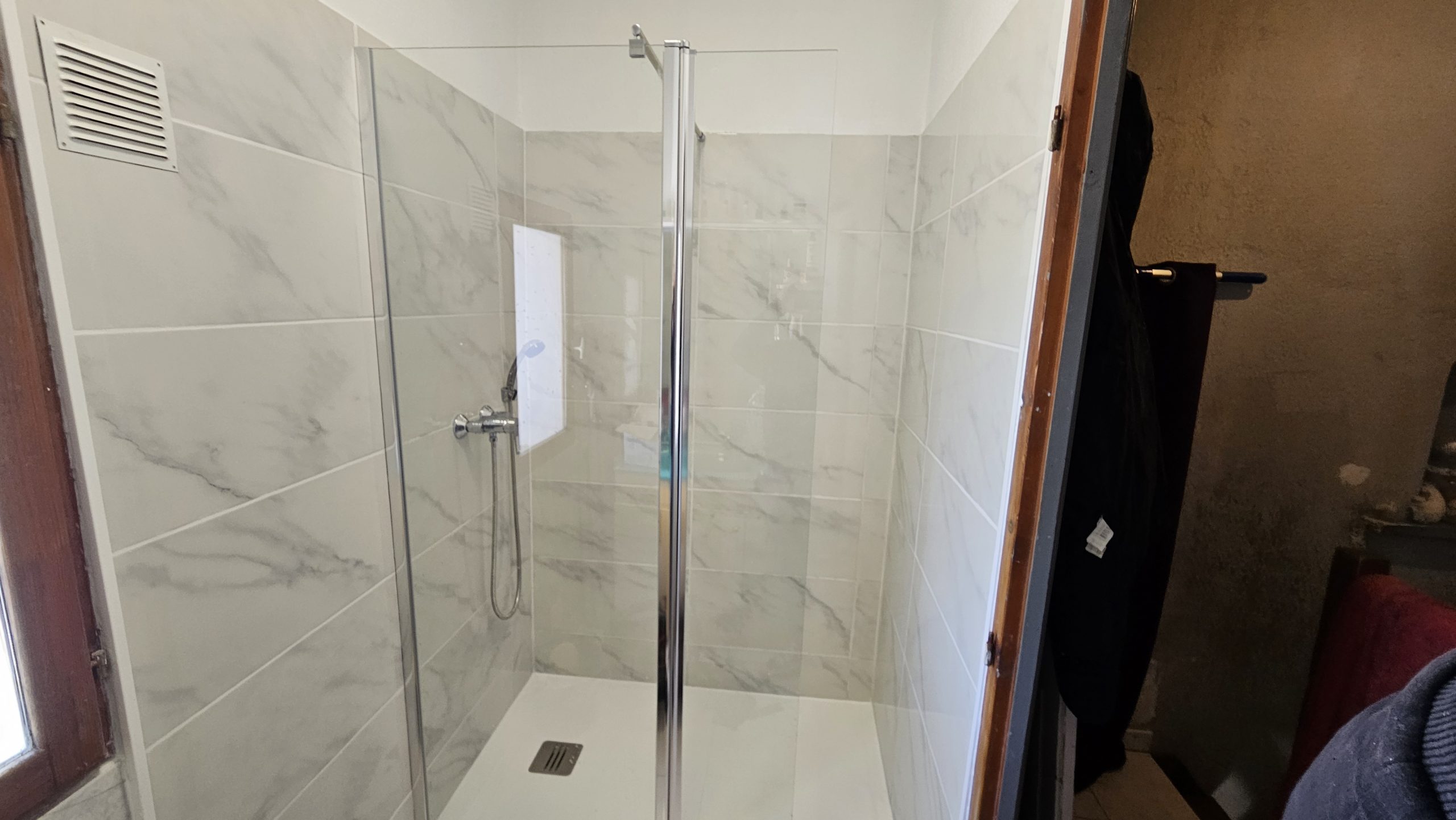 Douche à l’italienne installée à Marseille par Catanzaro Plomberie avec carrelage effet marbre et parois vitrées